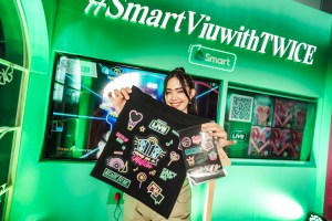An attendee shows off the prizes she won in the Smart TWICE booth.